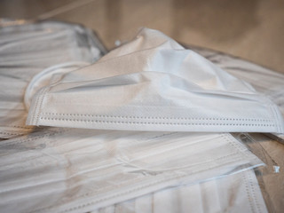A pile of white surgical masks used to prevent the spread of viruses