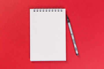 top view of blank open notebook on red background, office equipment, school supplies and education concept
