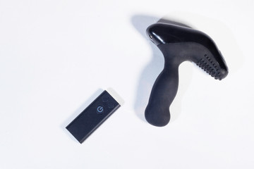 Mechanical vibrating  anal plug with a remote control on a white background, top view. Sex game. Prostate massage.
