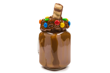 Chocolate milkshake with whipped cream, cookies, waffles, served in glass mason jar. 