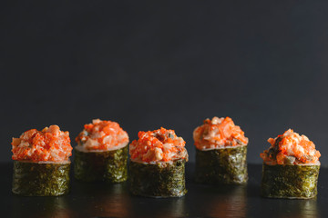 Set of five pieces of spicy Maki sushi rolls with sauced slices of smoked Eel, cheese and caviar of flying fish. © zhinna