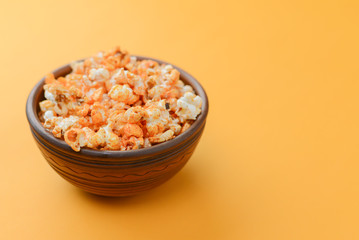 Fototapeta na wymiar Salty or sweet butter popcorn in a bowl isolated on bright yellow background. Snack in the house or cinema.