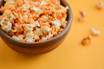 Fototapeta na wymiar Salty or sweet butter popcorn in a bowl isolated on bright yellow background. Snack in the house or cinema.