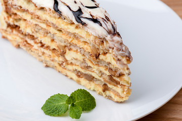 Esterhazy cake sliced on white plate. Sweet dessert with almond meringue dough and buttercream. Austrian cuisine.
