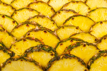 Pineapple juicy yellow slices background. Top view.
