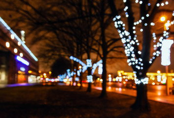 Street city lights out of focus at night, bokeh, decoration on the trees