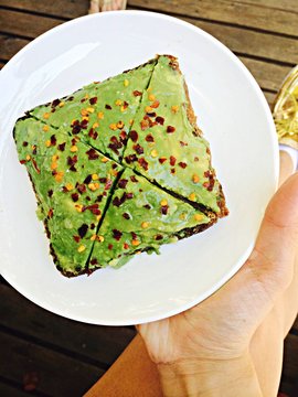 Close-up Of Hand Holding Avocado Toast