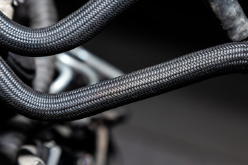 Two rubber pipes for gas or liquid covered with braided heat-resistant plastic winding for use in...