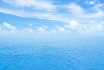 Ocean or sea calm water. Horizon line with partly cloud sky.