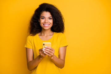 Fototapeta premium Close-up portrait of her she nice attractive lovely cheerful cheery confident wavy-haired girl using gadget sending sms message isolated over bright vivid shine vibrant yellow color background