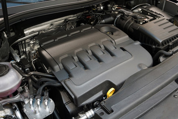 Close-up of the engine of a modern luxury car, the cover protects the engine from dust and dirt. The concept of quality service and repair of a modern luxury car.