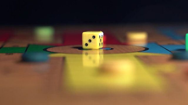 Dice in the middle of a wooden board. Ludo Game