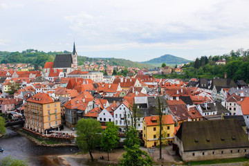 Aerial panoramic view of the typical colorful houses of Cesky Krumlov with Vltava river at the foreground and St. Vitus Church at the background (Czech Republic)