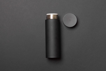 black thermos cup with open cover on black background