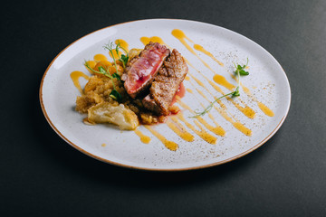 Duck breast fillet with quinoa garnish with young pea sprouts on a black background
