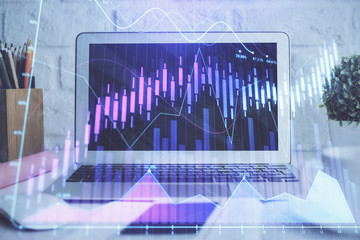 Stock market graph on background with desk and personal computer. Multi exposure. Concept of financial analysis.