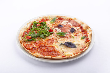 Delicious fresh pizza on table. Pizza four seasons. Fresh Italian Four Seasons Pizza (Pizza Quattro Stagioni) on the wooden board on the kitchen table. Homemade delicious italian pizza on wooden table