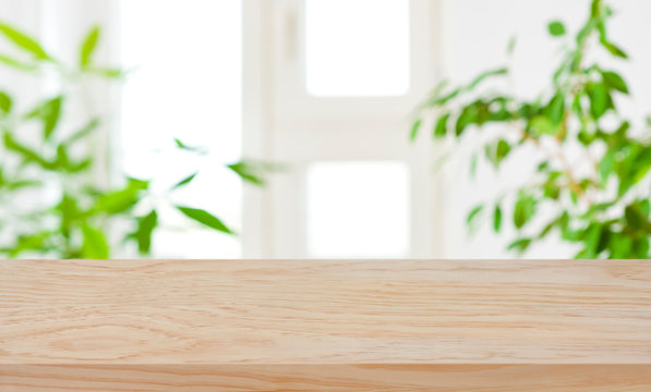 Wood Table Top On Blur Window And Green Plants Background