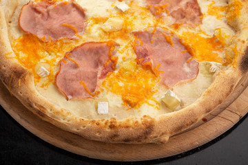 Delicious fresh pizza on table.  Delicious pizza. Large meat pizza with bacon, sausage, salami, pepperoni and olives. Homemade delicious italian pizza on wooden table for dinner. Italian cuisine.