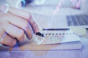 Multi exposure closeup hands with stock market forex graph.