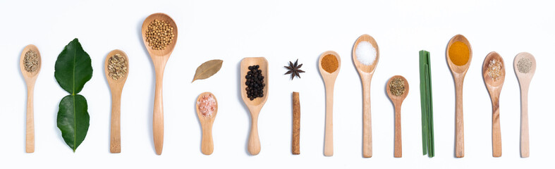 Various spices in wooden spoons, isolated background