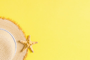 yellow retro straw hat with seastar top view with copy space. summer concept on yellow background
