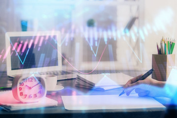 Financial graph displayed on woman's hand taking notes background. Concept of research. Multi exposure