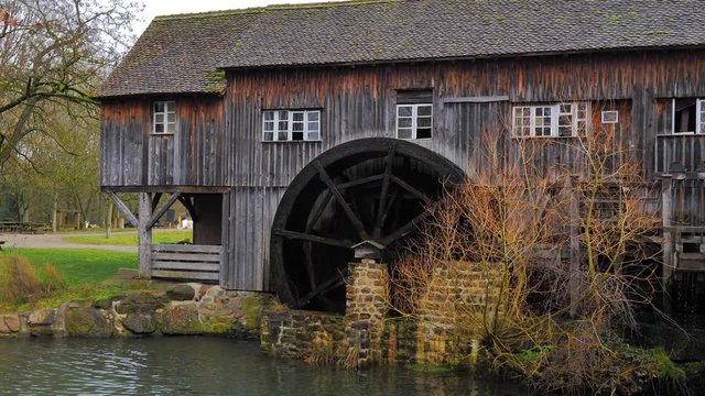 Rueda de madera de molino de agua giran sus aspas con el fluir del r&iacute;o
