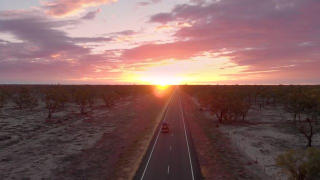 Small Van traveling the Australian outback at sunset