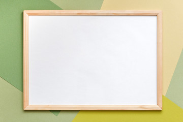Wood blank frame on geometric green shades paper background. Copy space, mockup for your design, text