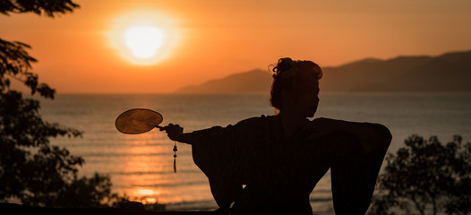 Silhouette of Japanese Geisha in kimono with fan