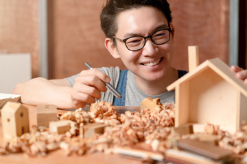 smart attractive handy glasses asian male craftman or interior designer focus wood working at site constrution home interior design renovation and improvement concept
