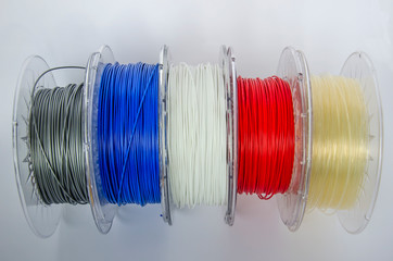 Plastic for 3D printing, different colors plastic filament, ABS/PLA coil for 3d printer on white...