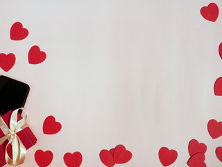 Valentine's day card. Composition with gifts, red hearts, mobile phone on white surface. Top view....