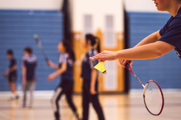 girl serving in badminton - obrazy, fototapety, plakaty