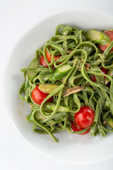 Traditional italian pasta. green spinach tagliatelle pasta with basil and anchovies in a plate on table. italian seafood. Homemade delicious italian traditional pasta on wooden table for dinner. itali
