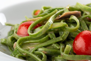 Traditional italian pasta. green spinach tagliatelle pasta with basil and anchovies in a plate on table. italian seafood. Homemade delicious italian traditional pasta on wooden table for dinner. itali