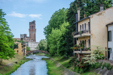 Fototapeta na wymiar View of canal in Italy. Galileo Astronomical Observatory La Specola Tower in Padova Italy on blue sky background, Padova, Italy
