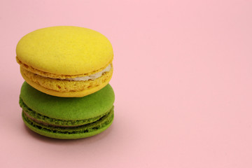 Colored macaroons or macarons on a pink background