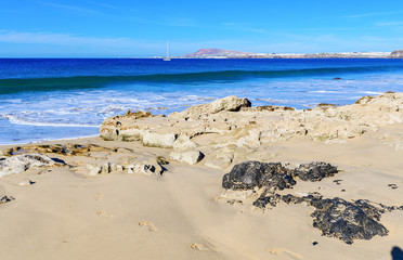 Fototapeta na wymiar View of beautiful Papagayo beach near town named Playa Blanca, Lanzarote, Canary Islands. View of blue sea, yellow sand, selective focus