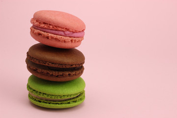 Stack of Colored macaroons or macarons on a pink background