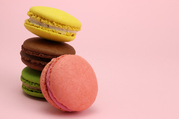 Stack of Colored macaroons or macarons on a pink background