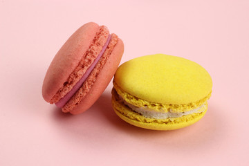 Colored macaroons or macarons on a pink background