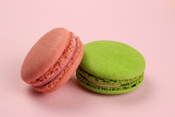 Colored macaroons or macarons on a pink background