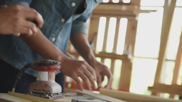 Young Asian group man worker discuss and planning about diy wood furniture in workshop. Slow motion footage