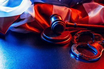 Gavel, handcuffs and american flag on dark background