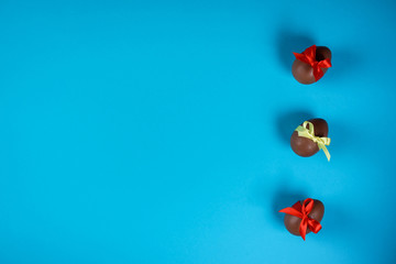 Three chocolate eggs on the blue background. Easter concept.