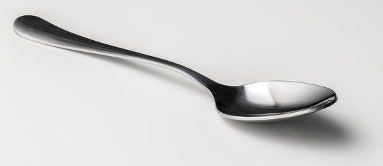 Silver dessert spoon cutlery on grey background