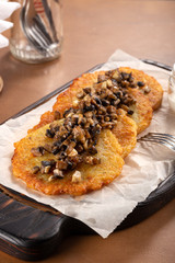 Potato pancakes with sour cream, herbs and garlic. Potato pancakes fried in butter. Potato pancake 