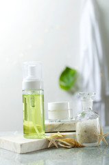 Vertical shot of bottle of cosmetics cream, lotion, gel on the bath table, bathrobe on the background.Concept of natural cosmetic products and essential beauty treatments